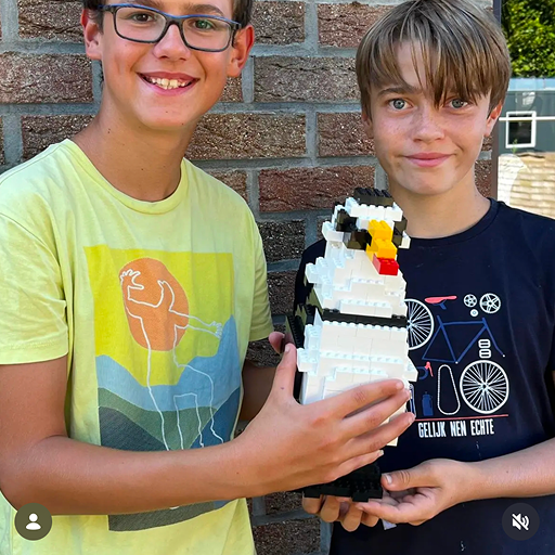 Twee kinderen tijdens een verjaardagsfeestje in Bird Palace die uit lego een pinguïn hebben gemaakt